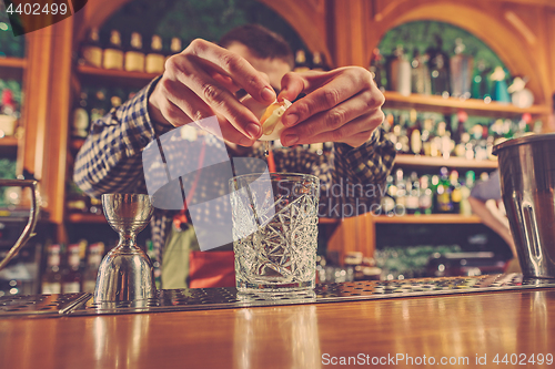 Image of Barman making an alcoholic cocktail at the bar counter on the bar background