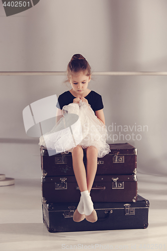 Image of The little girl as balerina dancer sitting at studio