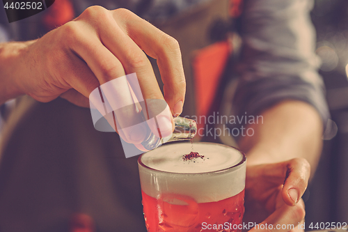 Image of Barman making an alcoholic cocktail at the bar counter on the bar background