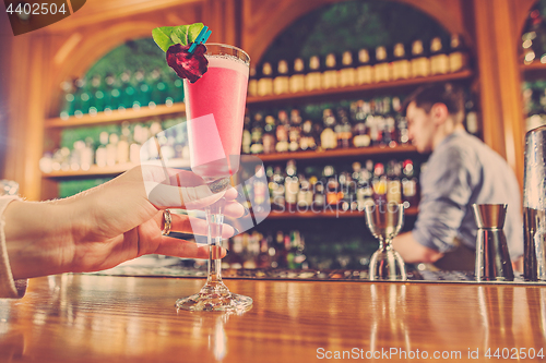 Image of The girl is holding in his hand a glass of alcoholic beverage