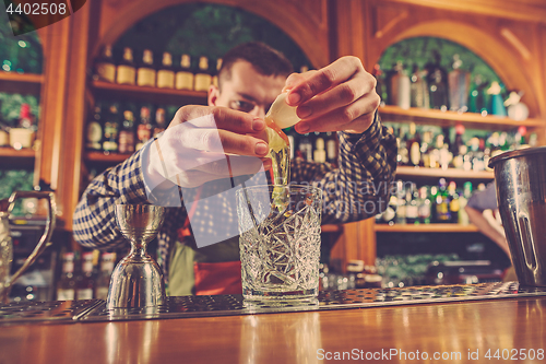 Image of Barman making an alcoholic cocktail at the bar counter on the bar background