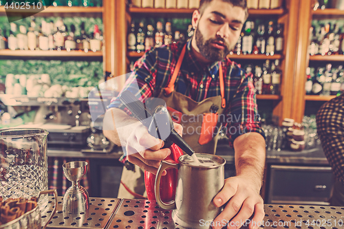 Image of Barman making an alcoholic cocktail at the bar counter on the bar background