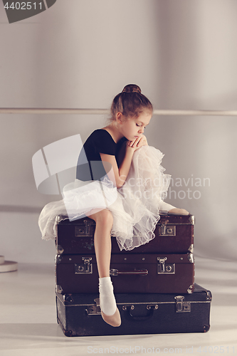 Image of The little girl as balerina dancer sitting at studio