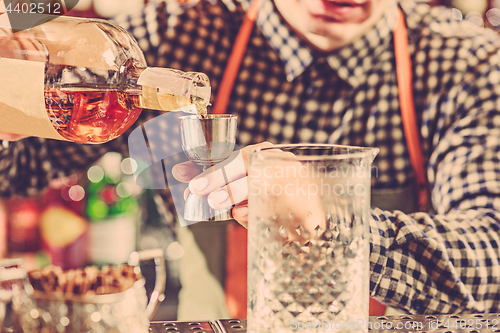 Image of Barman making an alcoholic cocktail at the bar counter on the bar background