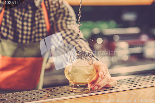 Image of Barman making an alcoholic cocktail at the bar counter on the bar background