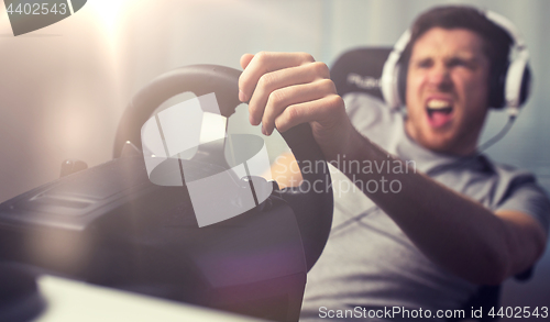 Image of close up of man playing car racing video game