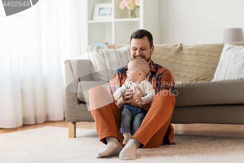 Image of happy father with little baby boy at home