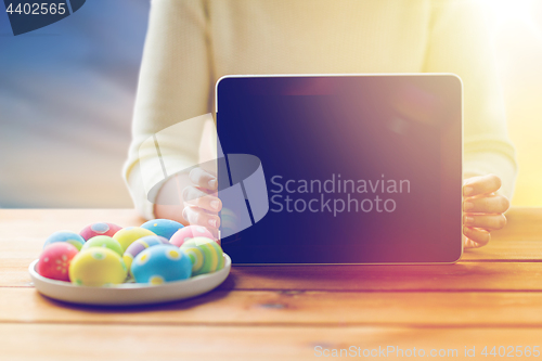 Image of close up of woman with tablet pc and easter eggs