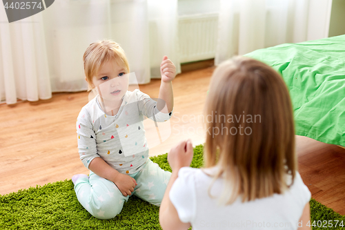 Image of girls playing rock-paper-scissors game at home