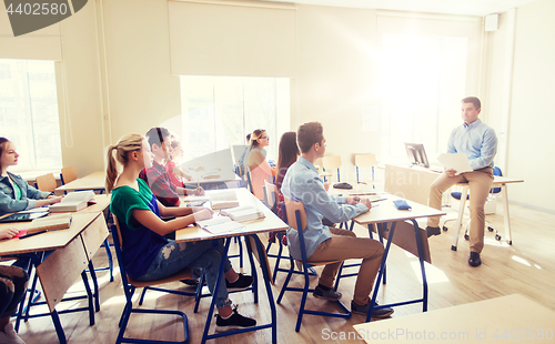 Image of group of students and teacher with papers or tests