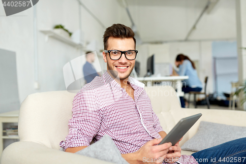 Image of man in glasses with tablet pc working at office