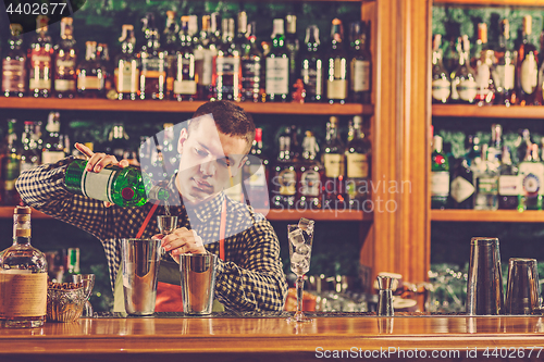 Image of Barman making an alcoholic cocktail at the bar counter on the bar background