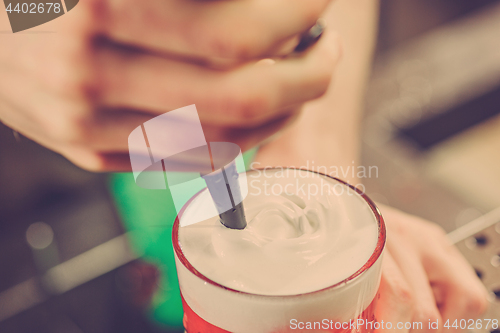 Image of Barman making an alcoholic cocktail at the bar counter on the bar background