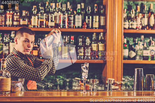 Image of Barman making an alcoholic cocktail at the bar counter on the bar background