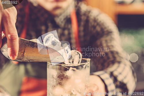 Image of Barman making an alcoholic cocktail at the bar counter on the bar background