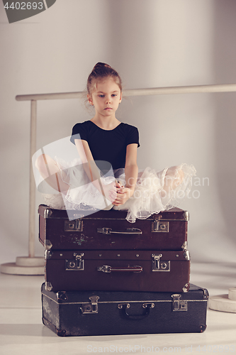 Image of The little girl as balerina dancer sitting at studio