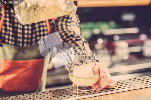 Image of Barman making an alcoholic cocktail at the bar counter on the bar background