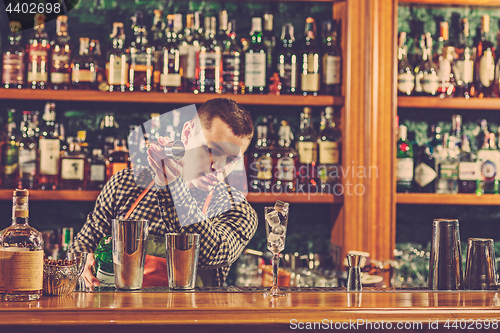 Image of Barman making an alcoholic cocktail at the bar counter on the bar background