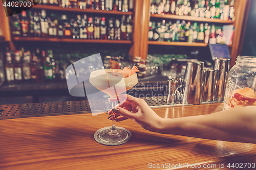 Image of The girl is holding in his hand a glass of alcoholic beverage