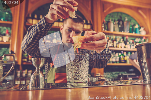 Image of Barman making an alcoholic cocktail at the bar counter on the bar background