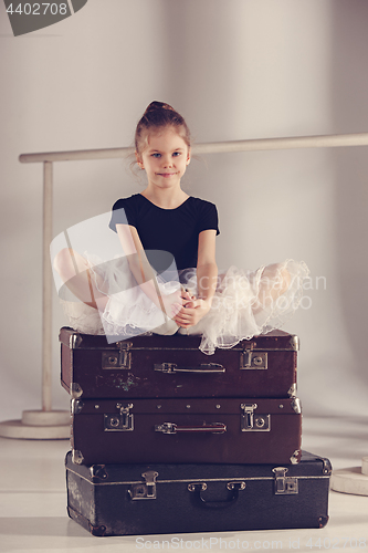 Image of The little girl as balerina dancer sitting at studio