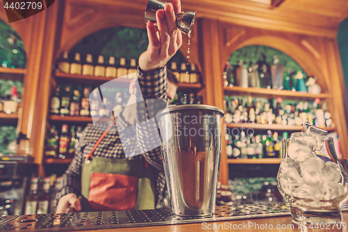 Image of Barman making an alcoholic cocktail at the bar counter on the bar background