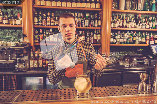 Image of Barman making an alcoholic cocktail at the bar counter on the bar background