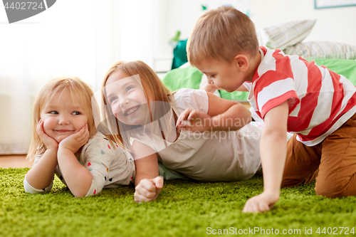 Image of happy little kids lying on floor or carpet