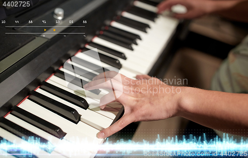 Image of hands playing piano at sound recording studio