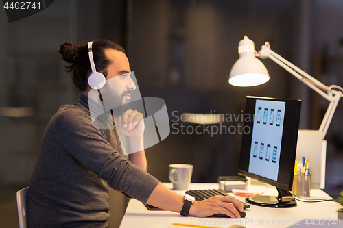 Image of creative man with headphones working at office