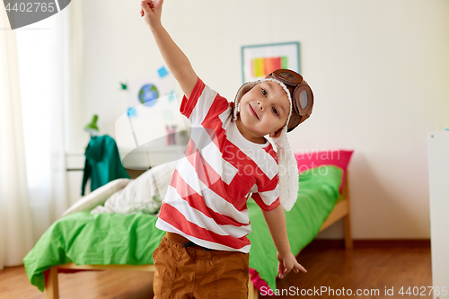 Image of happy little boy in pilot hat playing at home