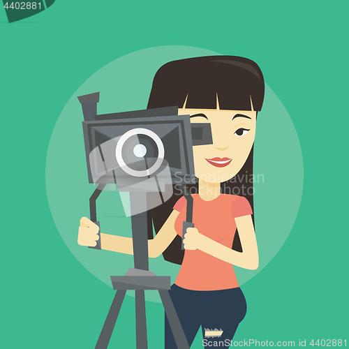 Image of Cameraman with movie camera on tripod.