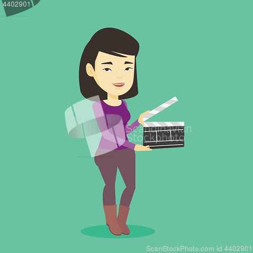 Image of Smiling woman holding an open clapperboard.