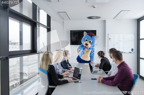 Image of boss dresed as bear having fun with business people in trendy of