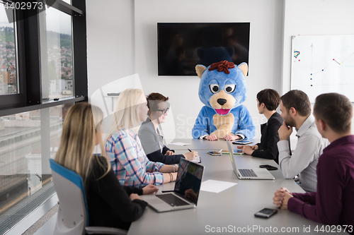 Image of boss dresed as bear having fun with business people in trendy of