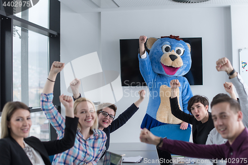 Image of boss dresed as bear having fun with business people in trendy of