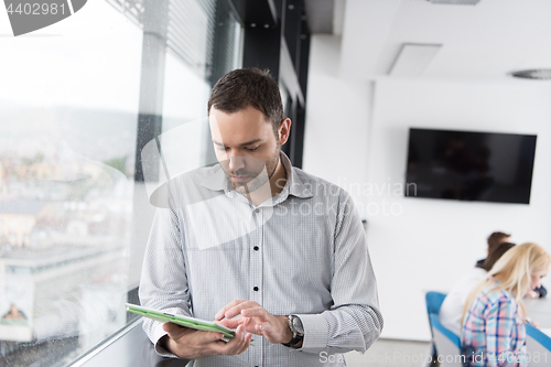 Image of Businessman Using Tablet In Office Building by window