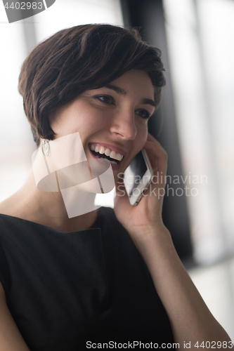 Image of Elegant Woman Using Mobile Phone in office building