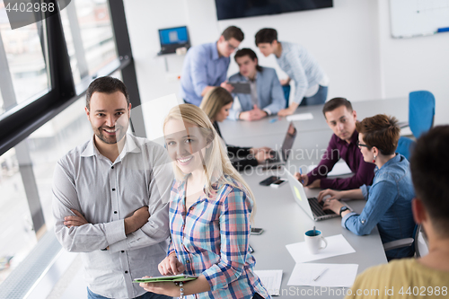 Image of Two Business People Working With Tablet in office