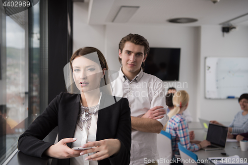 Image of Elegant Woman Using Mobile Phone by window in office building