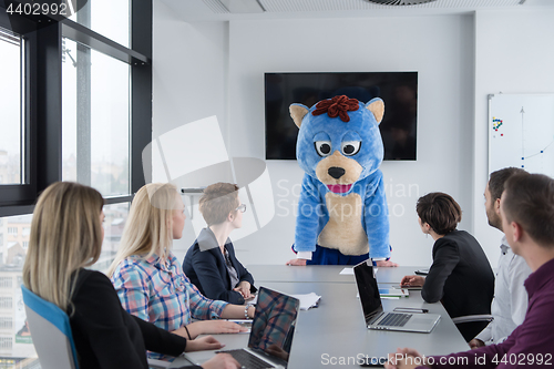 Image of boss dresed as bear having fun with business people in trendy of