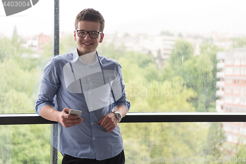 Image of Businessman Standing In A Modern Building Near The Window With P