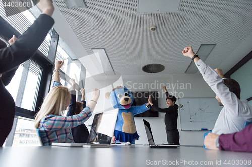 Image of boss dresed as bear having fun with business people in trendy of