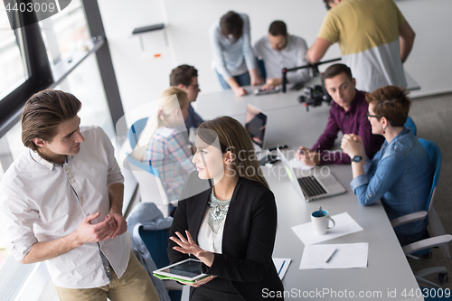 Image of Two Business People Working With Tablet in office