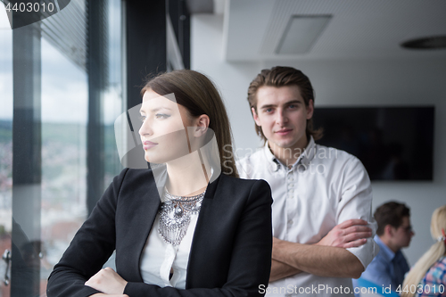 Image of Elegant Woman Using Mobile Phone by window in office building