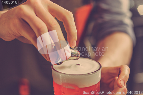 Image of Barman making an alcoholic cocktail at the bar counter on the bar background