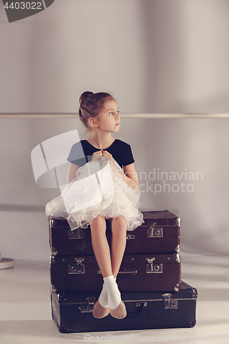 Image of The little girl as balerina dancer sitting at studio
