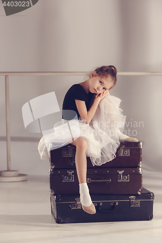 Image of The little girl as balerina dancer sitting at studio