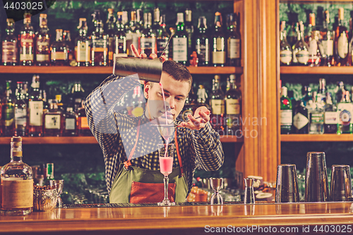 Image of Barman making an alcoholic cocktail at the bar counter on the bar background
