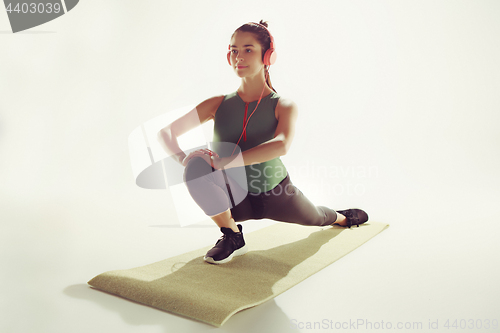 Image of Front view of a young woman stretching body in gymnastics class.